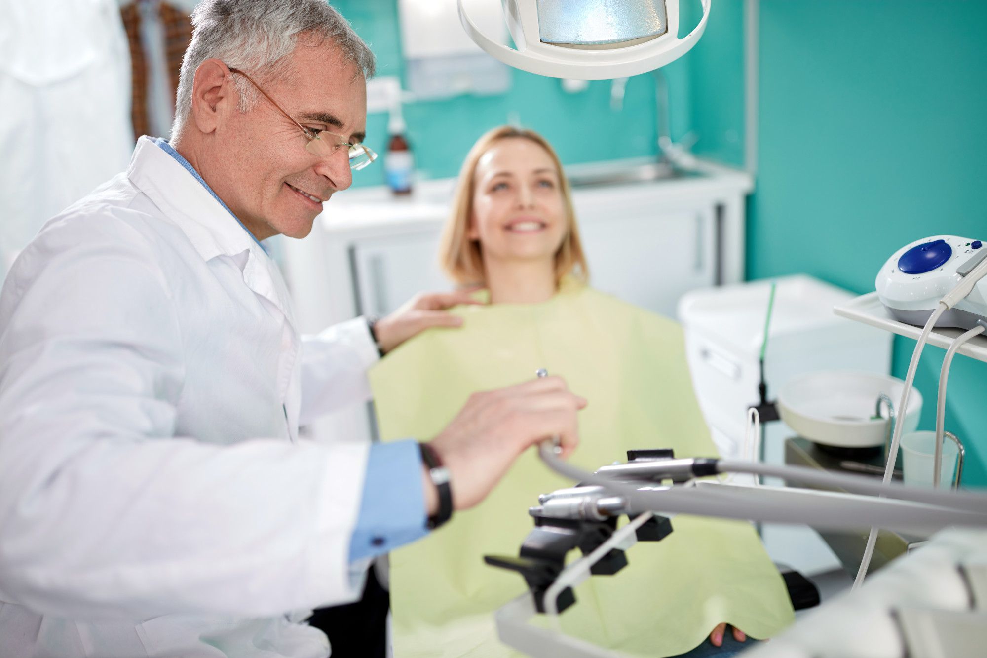 Male dentist with patient in dental practice choose instrument for work